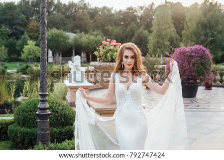 Beautiful young caucasian woman in luxury tulle wedding dress with plume on the castle.