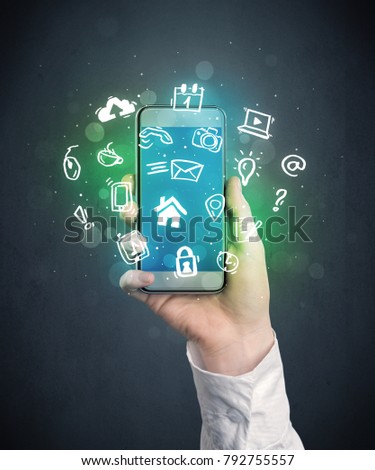 Caucasian hand in business suit holding a smartphone with drawn web icons
