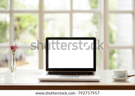 blank display laptop on wood table with coffee by window light
