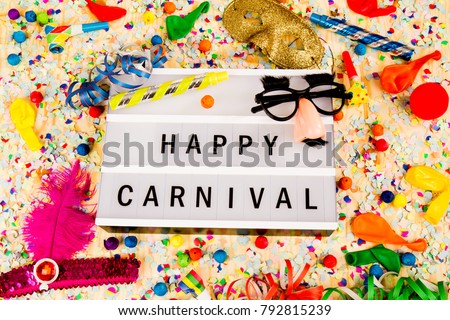 Lightbox with letters - HAPPY CARNIVAL - on colorful festive party decoration with steamers, confetti and balloons.