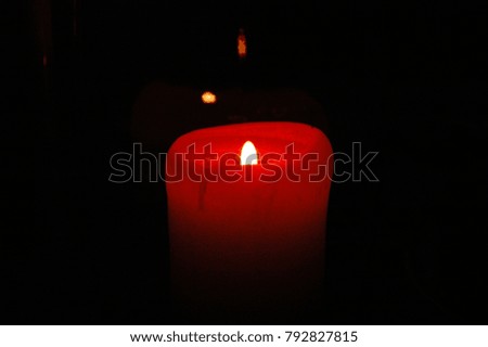 A beautiful candle burns in total darkness.