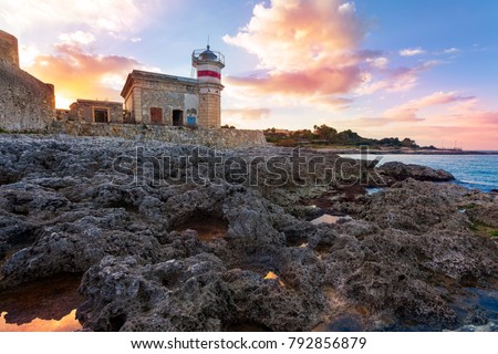 The castle of Brucoli and the little lighthouse reflected in a puddle, Syracuse, Sicily, Italy