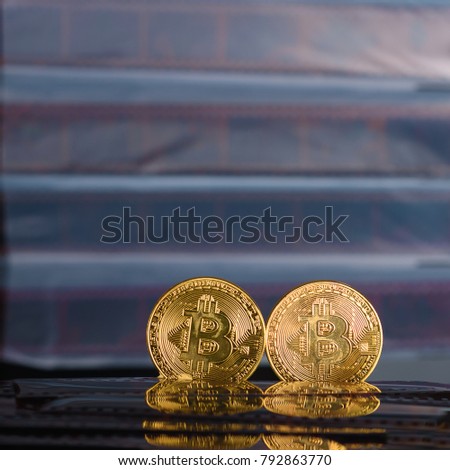  Two  cryptocurrency  bitcoin over Exposed and Developed old film negative strips background.