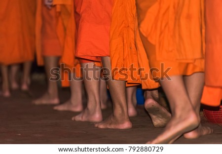 The feet of monks close-up. Feeding the monks. The ritual is called Tak Bat, Luang Prabang, Laos