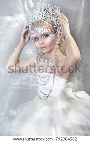 close up portrait of beautiful girl with crown. professional winter makeup. little snow queen