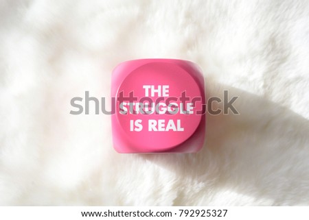 Pink button with white lettering that says "The Struggle is Real" on white background