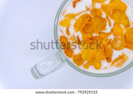 Close up image: a glass of milk with cereal (cornflakes) isolated on white background. Breakfast concept.