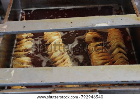 Potato chips being fried Royalty-Free Stock Photo #792946540