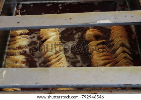 Potato chips being fried Royalty-Free Stock Photo #792946546