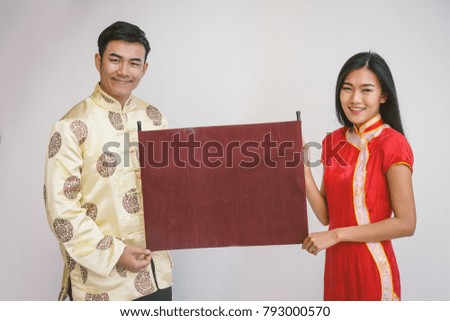 Young asian couple holding banner with Chinese new year.