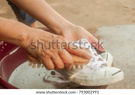 the hand washing a dirty white shoes at home