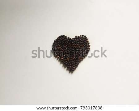 Beautiful black pepper heart shape with white background.