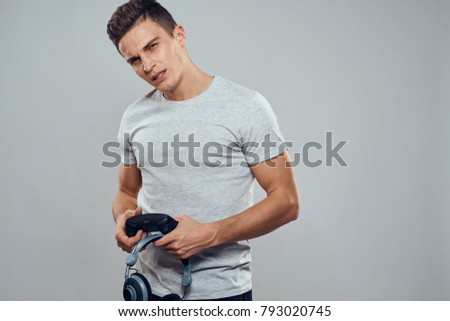  man with a joystick playing a console on a gray background                               