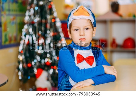 a boy in carnival costume in kindergarten, penguin costume, Christmas tree