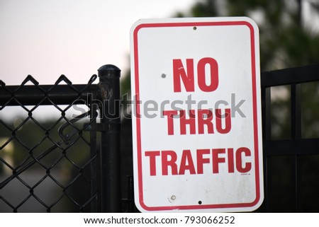 no thru traffic sign on fence dusk close macro
