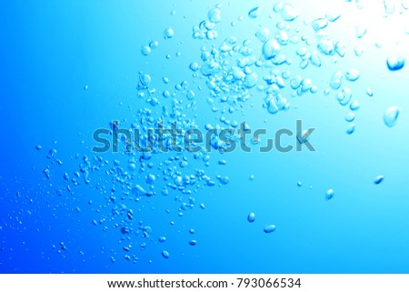 Bubbles underwater in clear blue sea