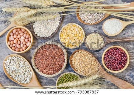 Varous kinds of natural grains consisted of red and green bean, soybeans, wheat, millet, and rice seeds put in grunge vintage wooden background decorated with dry wheat, for agricultural food concept Royalty-Free Stock Photo #793087837