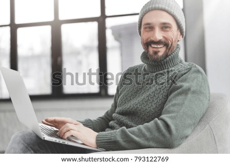 Smiling middle aged male enterpreneur checks corporate balance, makes money transfer online, works on modern laptop computer, connected to wireless internet. Blogger reads news on social networks
