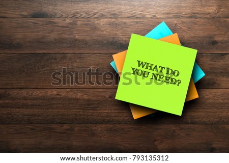 What Do You Need, the phrase is written on multi-colored stickers, on a brown wooden background. Business concept, strategy, plan, planning. Royalty-Free Stock Photo #793135312