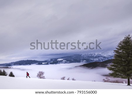 A woman walks up the hill with snow