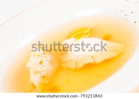 Dumplings in broth with an egg yolk on a white background