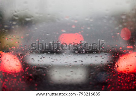 Blurred Red Brake Light and Some Raindrop During Rainy Day Traffic Jam