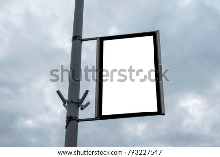 Blank billboard on a street light pole against clouds