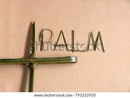 Palm leaf set cross to crucifix with palm leaf set to the word "palm" on the brown paper background. Concept of Palm Sunday and Holy week.