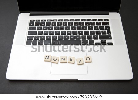 Virtual currency called Monero written with letters on a modern laptop. Cryptocurrency concept image.