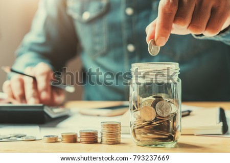 businessman holding coins putting in glass. concept saving money for finance accounting Royalty-Free Stock Photo #793237669
