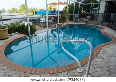 Home inground pool in the yard with protective mesh, South Florida, Cape Coral, usa