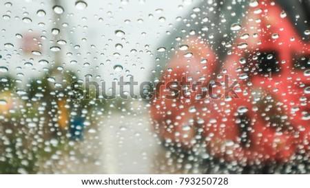 Rain drops into the glass until the picture blur.