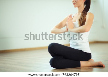 yoga, training and lifestyle concept - smiling woman stretching leg on mat in gym