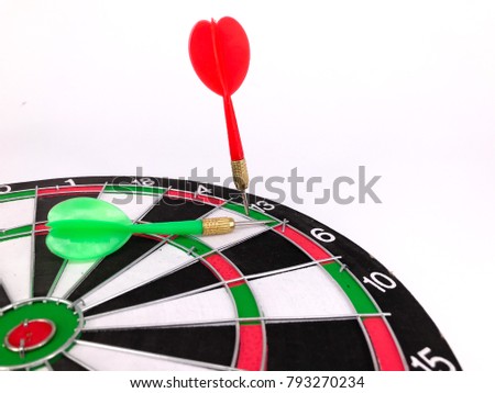 Dart arrow hitting in the target of dartboard on white background. Selective focus.