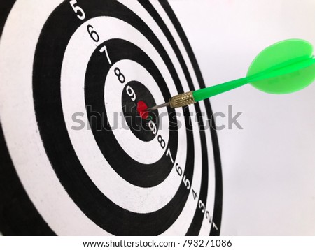 Dart arrow hitting in the target of dartboard on white background. Selective focus.