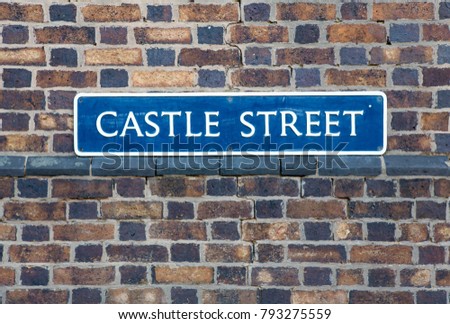 Road Sign on a brick wall reading "Castle Street" in Warwick, Warwickshire, UK.