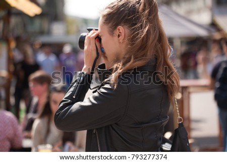 Fashionable young tourist woman photographing the city. 