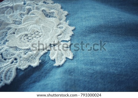 White lace on blue fabric.