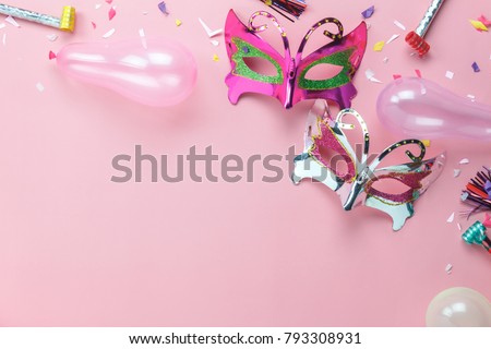 Flat lay aerial image of beautiful purple silver carnival mask for carnival holiday background concept. Table top view object on modern rustic pink paper at home office desk studio.space for creative.