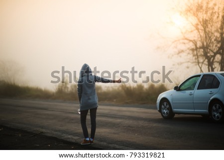 girl hitchhiking on the road