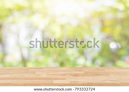 Empty wooden desk of free space and spring time with blurred background of home garden for a catering or food background,Template mock up for display montages of product.
