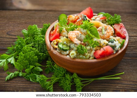 delicious gigli t with shrimps and basil on a plate on a wooden background