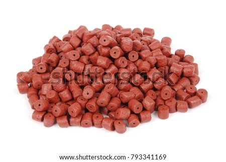 Red pre-drilled halibut pellets for carp fishing isolated on white background with soft shadow