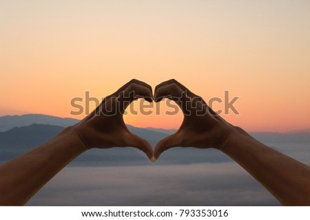 
Shadow image The girl's hand represents the symbol of the heart instead of love, compassion and friendship between the lover and the family on a beautiful of Sky background at sunrise in the morning. Royalty-Free Stock Photo #793353016