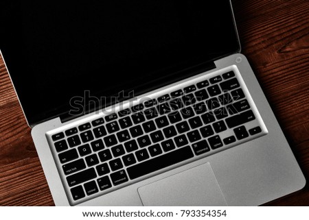 Laptop keyboard on the brown wooden desk.