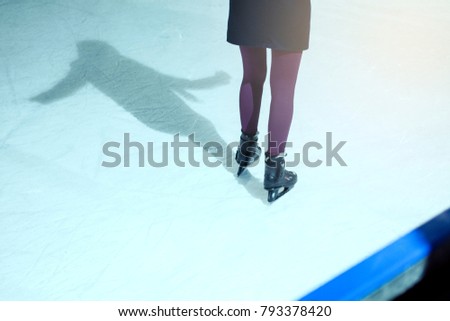   Unidentified rescue extreme women feale  on rink.  Ice Skaters skating on a public extreme rink , wearing blue violet uniform . Concept of learning skating.  