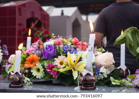 candles and flowers on grave