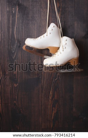 White ice skates on a wooden background