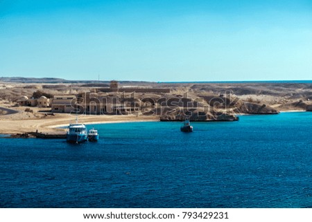 Quiet harbor with ships and sandy shores of the Red Sea.The desert connects to sea.