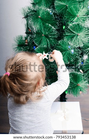 girl decorates a Christmas tree